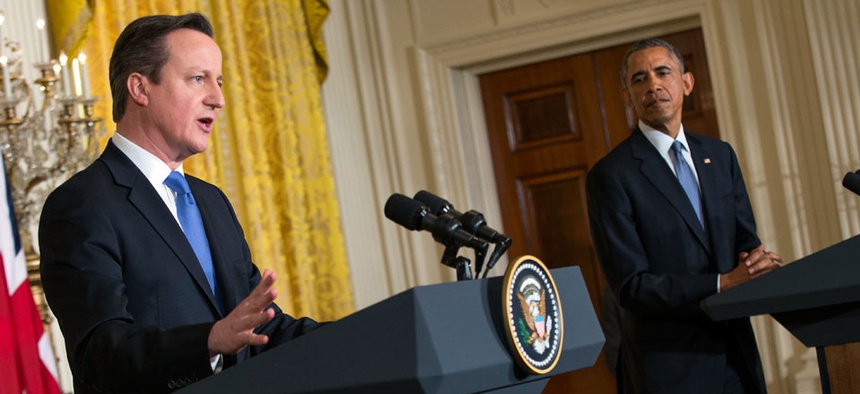 President Barack Obama listens as British Prime Minister David Cameron speaks during their joint news conference in the White House.