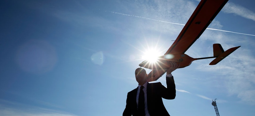 Dan Johnson of Sensurion Aerospace carries the Sensurion Aerospace Magpie commercial drone during an event Friday, Dec. 19, 2014, near Boulder City, Nev.