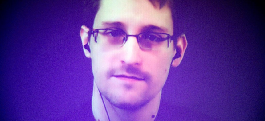Former U.S. National Security Agency contractor Edward Snowden, who is in Moscow, is seen on a giant screen during a live video conference for an interview with Amnesty International.