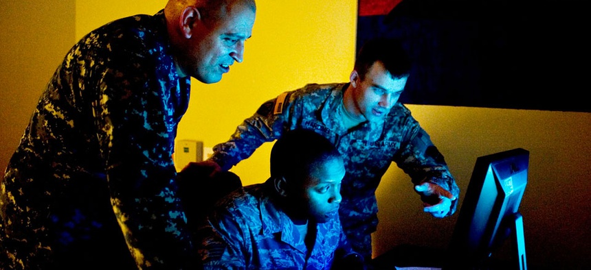 Three military cyber professionals conduct an exercise during Cyber Flag 13-1, Nov. 8, 2012, at Nellis Air Force Base, Nev.