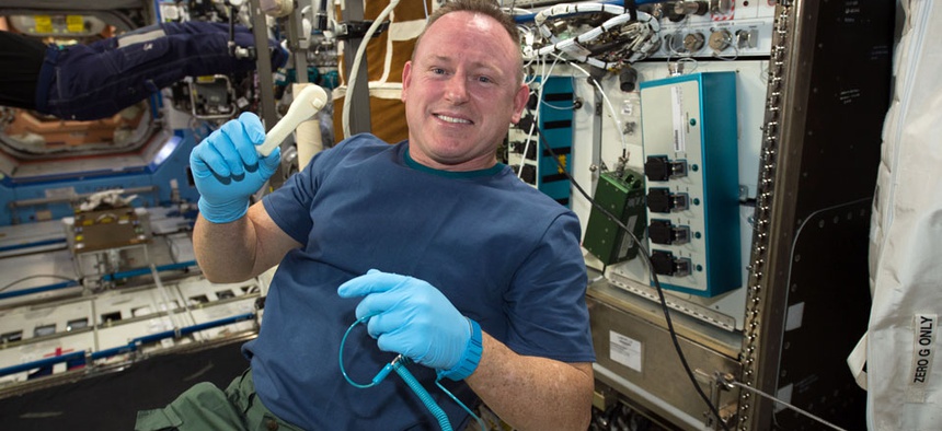 International Space Station Expedition 42 Commander Barry "Butch" Wilmore shows off a ratchet wrench made with a 3-D printer on the station.