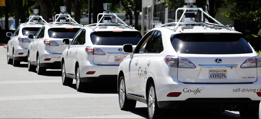 A row of Google self-driving cars are shown outside the Computer History Museum in Mountain View, Calif.