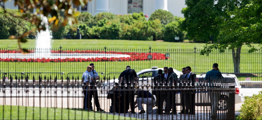 Security personnel are gathered at Lafayette Park near the White House in Washington, Thursday, May 14, 2015 during a lockdown. A federal law enforcement official says a man has been arrested after trying to launch a drone outside the White House fence.