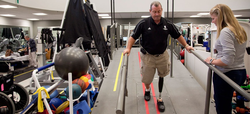 Vietnam veteran John Loosen, who lost a leg in Vietnam, shows off a new microprocessor-controlled prosthetic knee during a photo opportunity with his physical therapist Lindsay Martin, right, Wednesday, Aug. 18, 2010, at Walter Reed Army Medical Center.