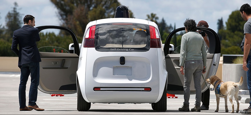 Riders enter the Google's new self-driving prototype car for a ride during a demonstration at Google campus on Wednesday, May 13, 2015.