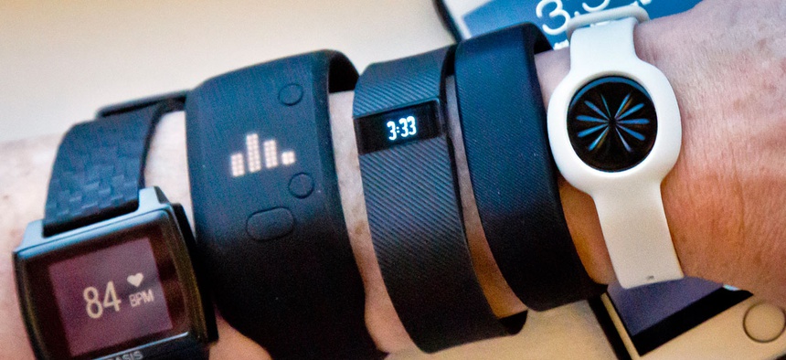 Fitness trackers, from left, Basis Peak, Adidas Fit Smart, Fitbit Charge, Sony SmartBand, and Jawbone Move, are posed for a photo next to an iPhone.