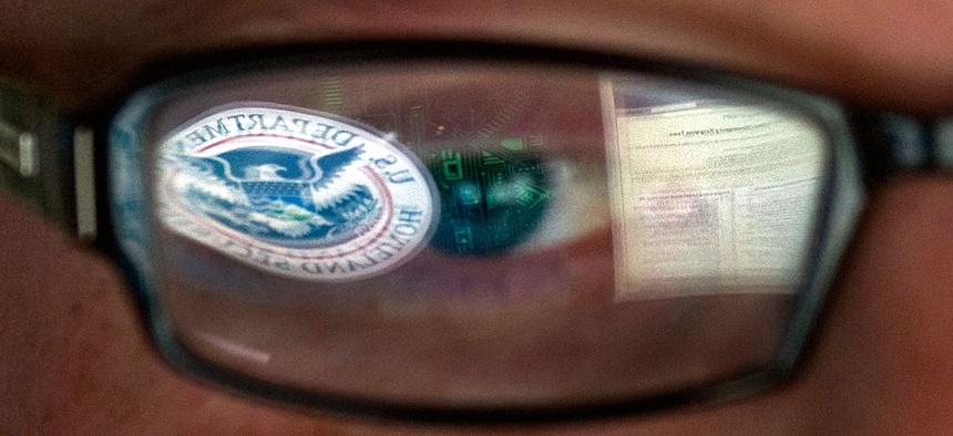 A reflection of the Department of Homeland Security logo in the eyeglasses of a cybersecurity analyst at the watch and warning center of the Department of Homeland Security's secretive cyber defense facility in Idaho Falls, Idaho.