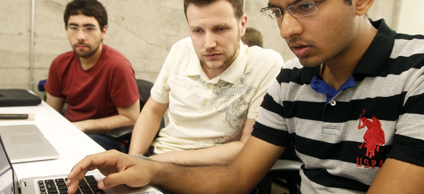 Shiva Gopalan, a computer engineering masters student at Texas A&M University (far right), confers with IBM developers Henrique Copelli Zambon (center) and Luiz Aoqui, during an IBM hosted Spark Hackathon in San Francisco on June 14, 2015.
