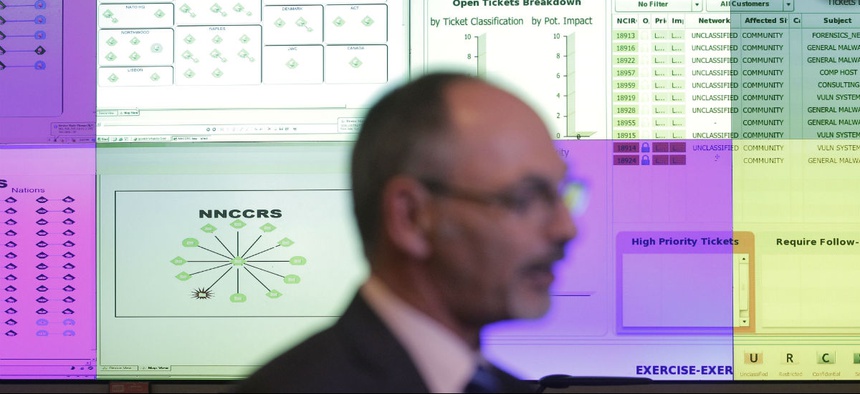 Director Ian West walks in front of computer screens at the NATO Computer Incident Response Capability technical center, at NATO's military headquarters.