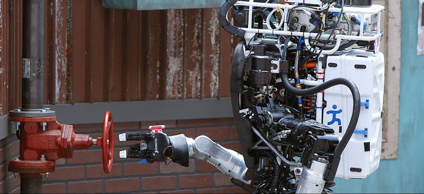 Robot Running Man from the Florida Institute for Human and Machine Cognition proceeds to turn a valve in the U.S. Defense Advanced Research Projects Agency Robotics Challenge in Pomona, Calif.