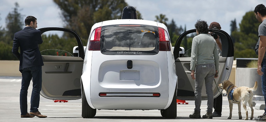 Riders enter the Google's new self-driving prototype car for a ride during a demonstration at Google campus on Wednesday, May 13, 2015, in Mountain View, Calif.