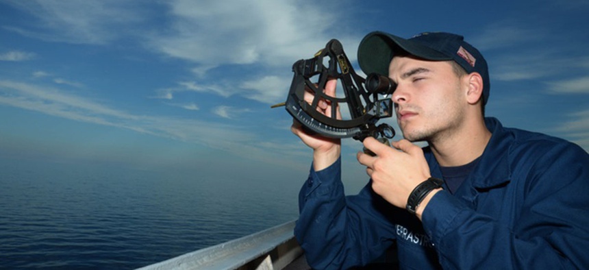 Quartermaster Seaman Pasquale V. Verrastro uses a sextant to find the range of a foreign vessel on the bridge wing of the guided-missile destroyer USS Ramage (DDG 61) in 2014.