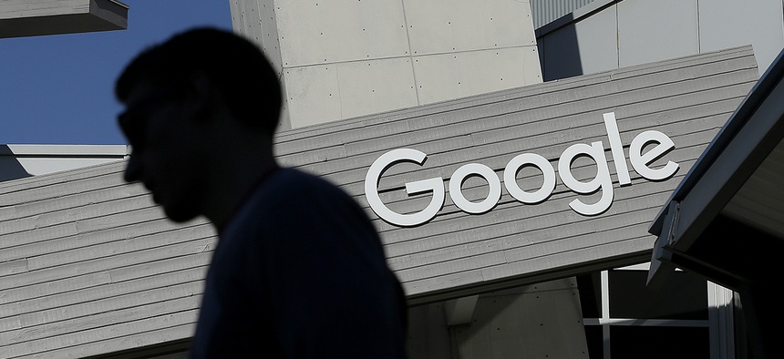 A man walks past a building on the Google campus in Mountain View, Calif.
