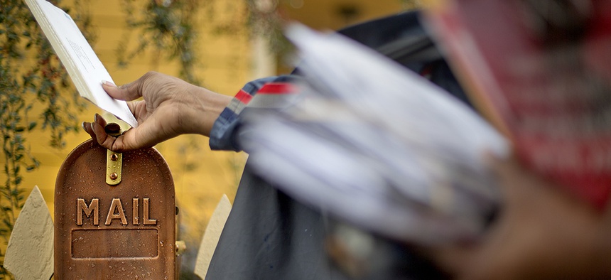 U.S. Postal Service letter carrier, Jamesa Euler, delivers mail, in Atlanta.