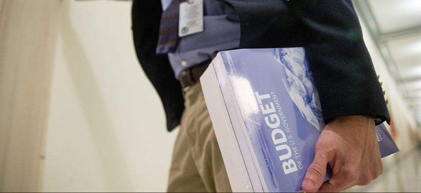 A Capitol Hill staff member holds a copy of President Barack Obama's fiscal 2017 federal budget.