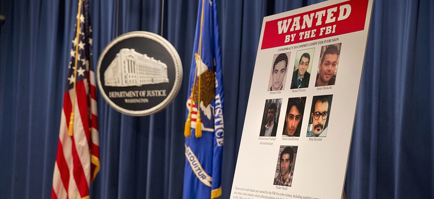 A poster lists Iranians who are wanted by the FBI for computer hacking, during a news conference at the Justice Department in Washington, Thursday, March 24, 2016.