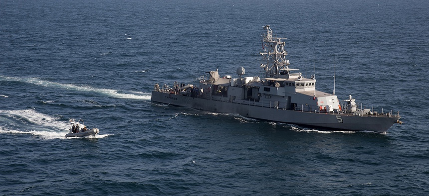 A rigid hull inflatable boat transits alongside the U.S. Navy coastal patrol ship USS Typhoon during a vertical onboard deliver exercise in the Arabian Gulf.