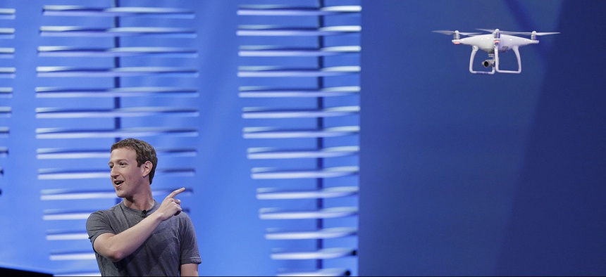 Facebook CEO Mark Zuckerberg points to a drone flying behind him during his keynote address at the F8 Facebook Developer Conference Tuesday, April 12, 2016