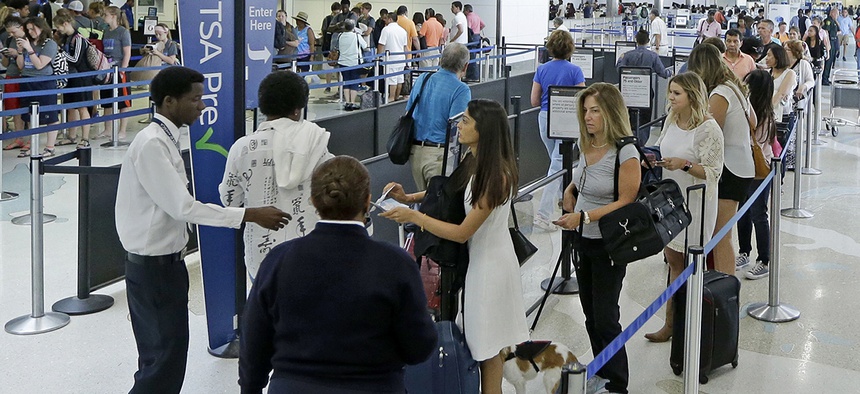 Travelers stand in line as they prepare to be screened a Transportation Security Administration checkpoint at Fort Lauderdale-Hollywood International Airport, Friday, May 27, 2016.