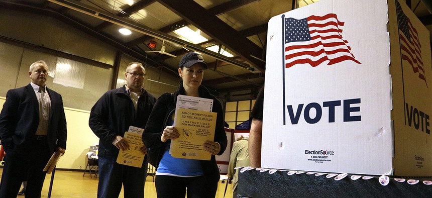 People line up to vote at a precinct Tuesday, March 15, 2016, in Bradfordton, Ill.