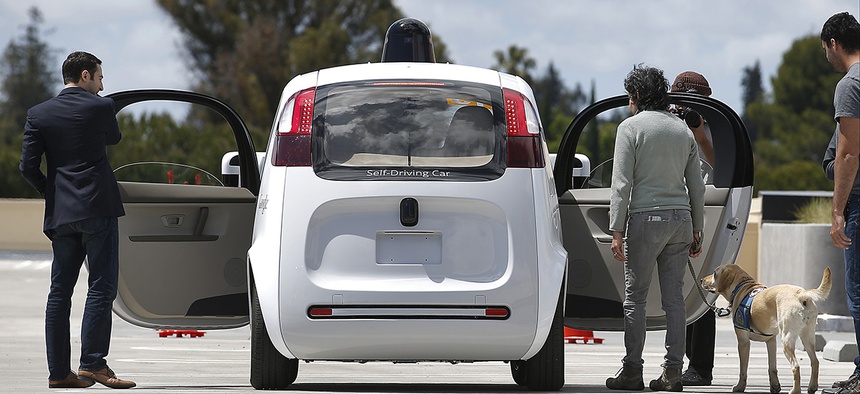 Riders enter the Google's new self-driving prototype car for a ride during a demonstration at Google campus on Wednesday, May 13, 2015.