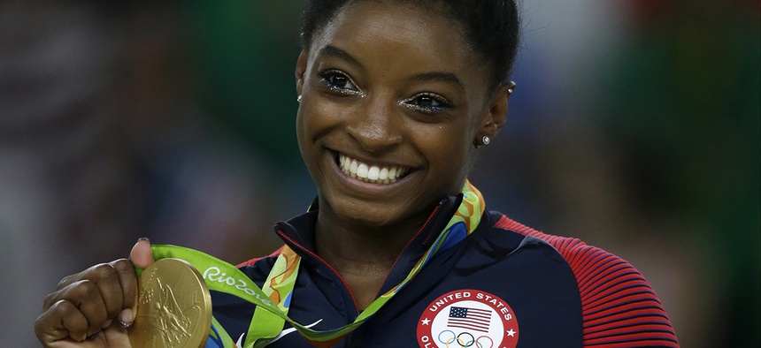 United States' Simone Biles displays her gold medal for floor during the artistic gymnastics women's apparatus final at the 2016 Summer Olympics.