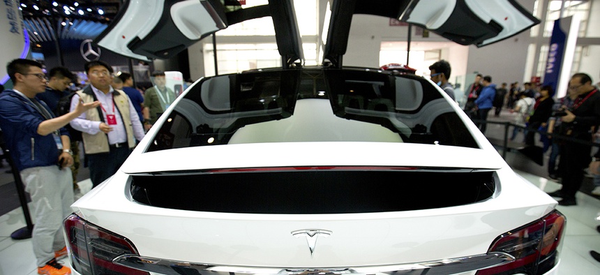 A visitor looks at a Tesla Model X on display at the Beijing International Automotive Exhibition.