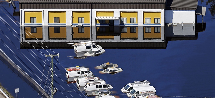 Vehicles at a business are surrounded by floodwaters from Hurricane Matthew in Lumberton, N.C., Wednesday, Oct. 12, 2016.