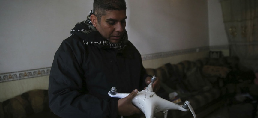 Iraqi special forces Lt. Col. Ali Hussein holds a destroyed drone used by Islamic State militants, which was shot down by his brigade, in the Bakr front line neighborhood, in Mosul, Iraq, Friday Nov. 25, 2016.