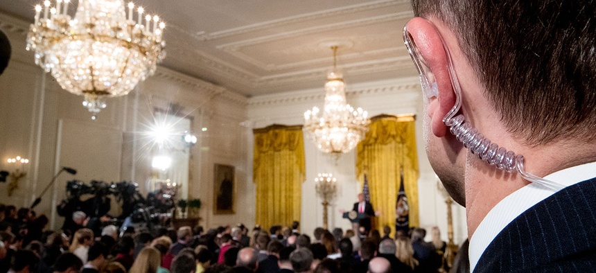 A Secret Service agent stands as President Donald Trump speaks during a news conference, Thursday, Feb. 16, 2017, in the East Room of the White House.