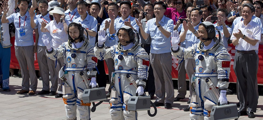China's astronauts from left, Wang Yaping, Zhang Xiaoguang and Nie Haisheng wave as they leave the Jiuquan satellite launch center near Jiuquan in western China's Gansu province, June 2013.