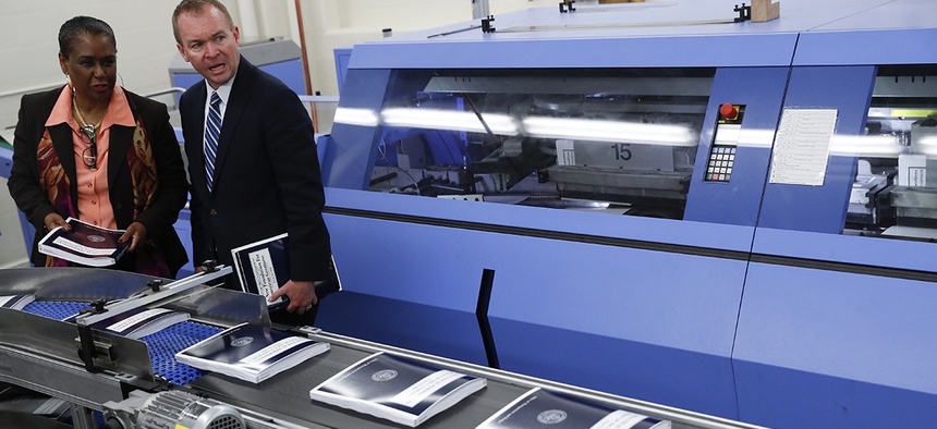 White House budget director Mick Mulvaney, right, joined by GPO Director Davita Vance-Cooks, inspects the production run of President Donald Trump's fiscal 2018 federal budget, May 19, 2017.
