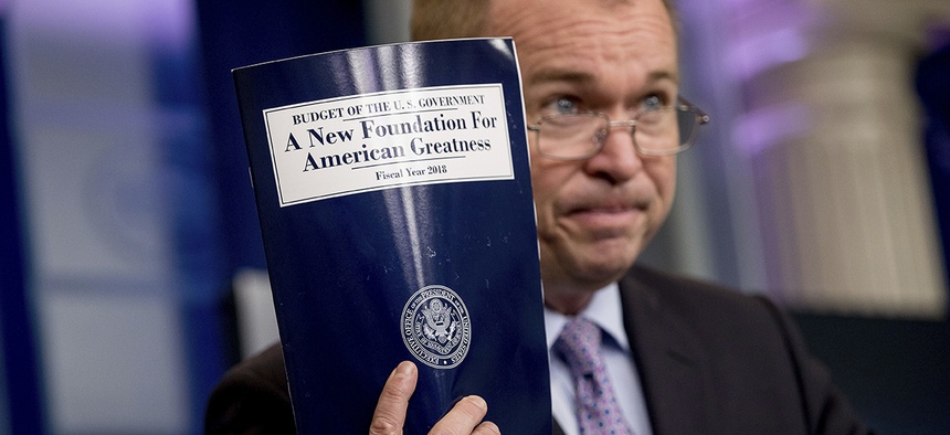 Budget Director Mick Mulvaney holds up a copy of President Donald Trump's proposed fiscal 2018 federal budget.