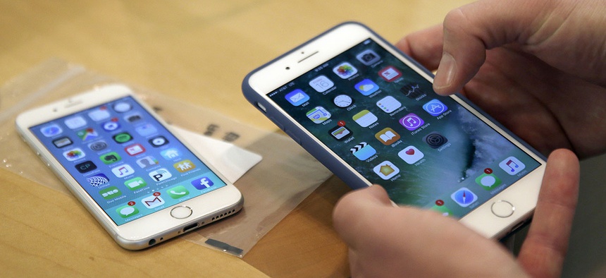 A customer sets up his new iPhone 7 Plus, right, as he switches from the iPhone 6 at the Apple Store.