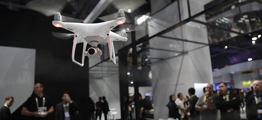 People watch a flying demonstration of a drone at the DJI booth at CES International Thursday, Jan. 5, 2017, in Las Vegas.