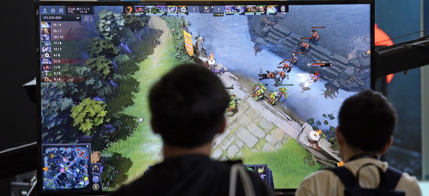 A monitor shows the game as fans look on at KeyArena during the International Dota 2 Championships Wednesday, Aug. 9, 2017, in Seattle.
