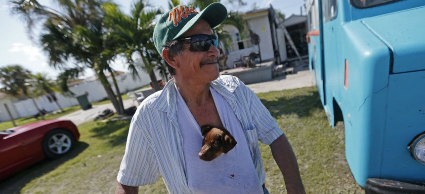 Nicolas Perez keeps a puppy he named "Irma," stuffed in his shirt, who he rescued from flooding in the aftermath of Hurricane Irma, in Immokalee, Fla.