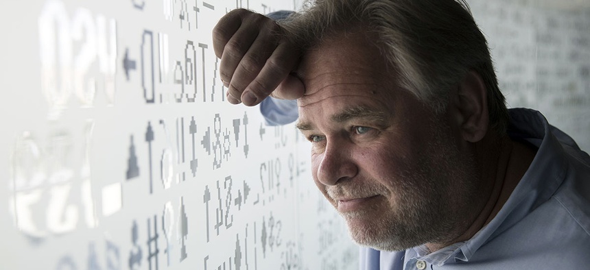 Eugene Kaspersky, Russian antivirus programs developer and chief executive of Russia's Kaspersky Lab, watches trough a window decorated with programming code's symbols at his company's headquarters in Moscow, Russia, Saturday, July 1, 2017.