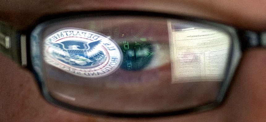 A reflection of the Department of Homeland Security logo is seen reflected in the glasses of a cyber security analyst in the watch and warning center at the DHS's secretive cyber defense facility at Idaho National Laboratory.