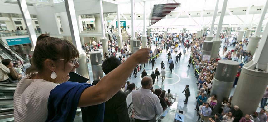 An unidentified U.S. citizen waves her flag to waiting family members after taking the citizenship oath during naturalization ceremonies at a U.S. Citizenship and Immigration Services (USCIS) ceremony in Los Angeles, Wednesday, Sept. 20, 2017.
