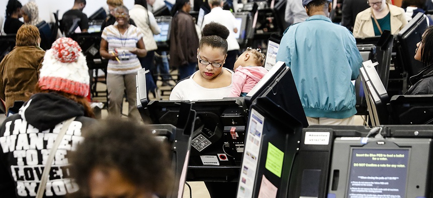 Early voters use electronic ballot casting machines at the Franklin County Board of Elections, Monday, Nov. 7, 2016, in Columbus, Ohio.