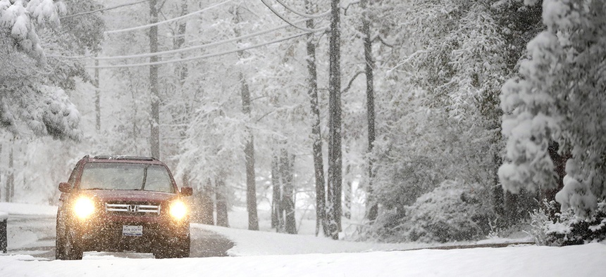 A vehicle drives along Lakeway Drive as snow covers the area following an early morning snowstorm, Friday, Dec. 8, 2017, in Brandon, Miss.