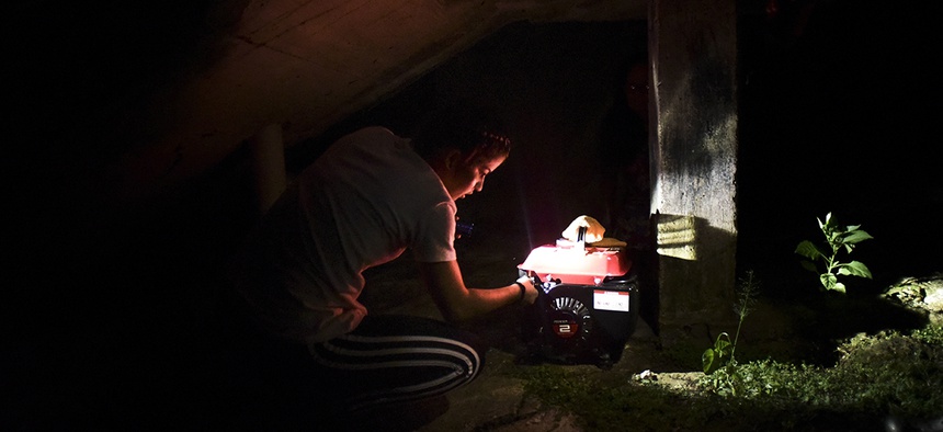 resident Karina Santiago Gonzalez works on a small power plant in Morovis, Puerto Rico.