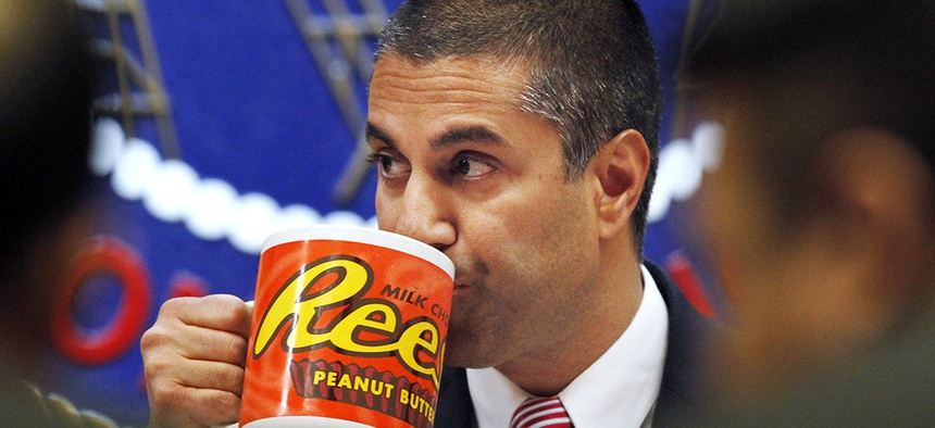 FCC Chairman Ajit Pai takes a drink from a mug during the meeting where the FCC voted on net neutrality, in Washington.