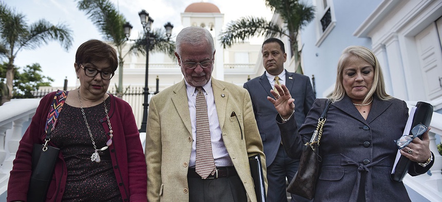 Puerto Rico secretary of the Department of Public Security, Hector Pesquera, center, Puerto Rico Justice Secretary Wanda Vazquez, right, and U.S. Attorney Rosa Emilia Rodriguez, head to give a press conference in San Juan, Puerto Rico.
