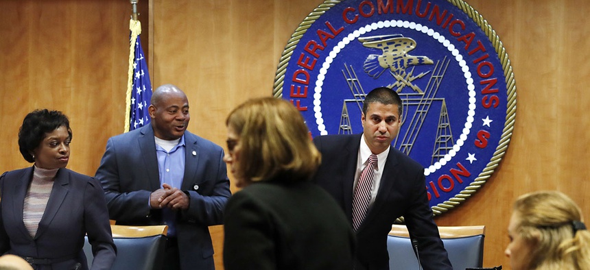 Federal Communications Commission Chairman Ajit Pai, right, and Commissioner Mignon Clyburn, far left, on Dec. 14 in Washington, D.C.