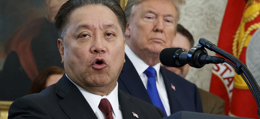 Broadcom CEO Hock Tan speaks while U.S. President Donald Trump listens, in background, during an event at the White House in Washington.