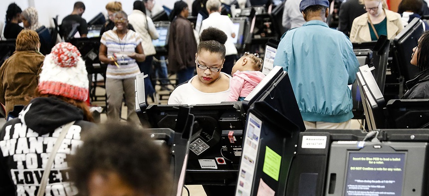 Early voters use electronic ballot casting machines at the Franklin County Board of Elections, Monday, Nov. 7, 2016, in Columbus, Ohio.
