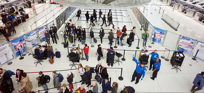 Passengers stand in line as they wait to pass through a TSA security checkpoint at JFK International Airport Friday, March 2, 2018.