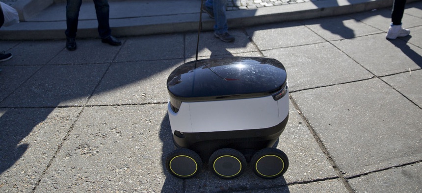 Six-wheeled ground delivery robot, from Estonia-based Starship Technologies, share the sidewalk with pedestrians at DuPont Circle, February 2017 in Washington.